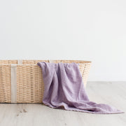 Purple organic cotton muslin swaddle in basket 