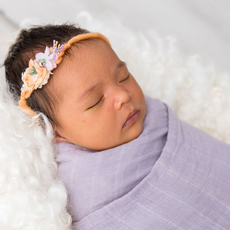 Baby wrapped in purple organic cotton swaddle baby